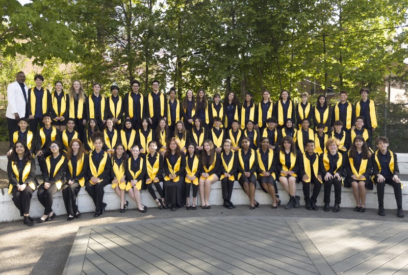 Toronto All Stars Steel Orchestra together outdoors, wearing black and yellow